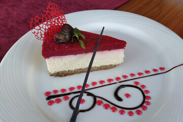 Cheesecake on a white plate. artistic cheesecake with raspberries and chocolate