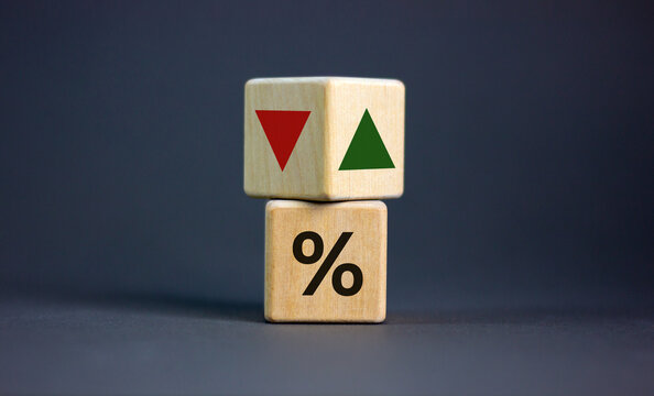 Wooden cubes changes the direction of an arrow symbolizing that the interest rates are going down or vice versa . Business concept. Copy space, beautiful grey background.
