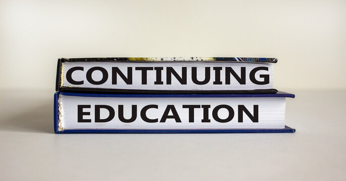 Books with text 'continuing education' on beautiful white table. White background. Business concept. Copy space.