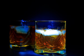 glass of whiskey on blue