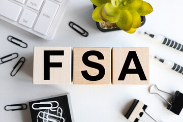 FSA, text on wood cubes on light background, business concept