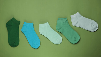 Set of colored socks on green background. Top view