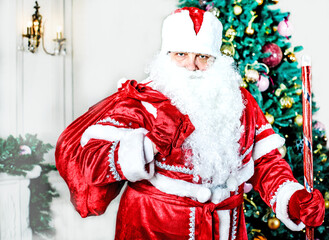 Santa Claus with a bag of gifts on the background of the Christmas tree. New year and Christmas celebrations. Russian holiday.