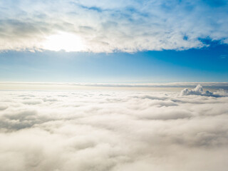 Aerial view. Flying over white clouds during the day in sunny weather.