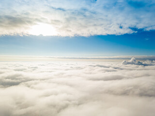 Aerial view. Flying over white clouds during the day in sunny weather.