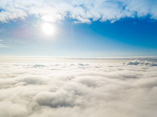 Aerial view. Flying over white clouds during the day in sunny weather.