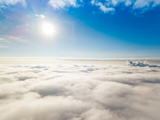 Aerial view. Flying over white clouds during the day in sunny weather.