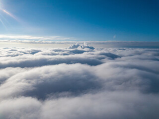 Aerial view. Flying over white clouds during the day in sunny weather.