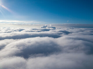Aerial view. Flying over white clouds during the day in sunny weather.