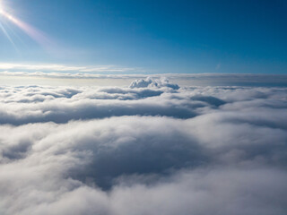Aerial view. Flying over white clouds during the day in sunny weather.