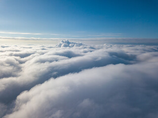 Aerial view. Flying over white clouds during the day in sunny weather.