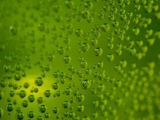 Bubbles of soda on a green background close up.