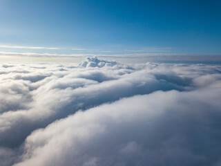 Aerial view. Flying over white clouds during the day in sunny weather.