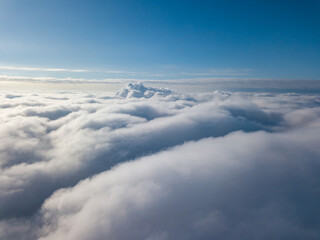 Fototapeta na wymiar Aerial view. Flying over white clouds during the day in sunny weather.