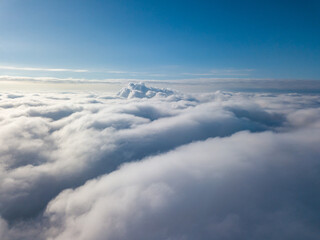 Aerial view. Flying over white clouds during the day in sunny weather.