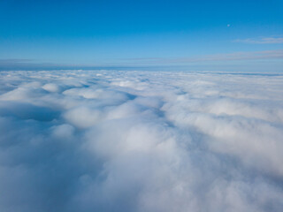 Aerial view. Flying over white clouds during the day in sunny weather.