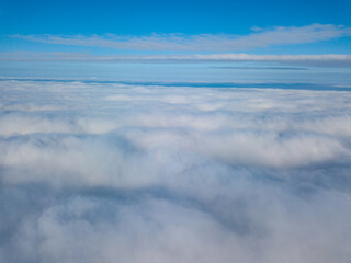 Aerial view. Flying over white clouds during the day in sunny weather.