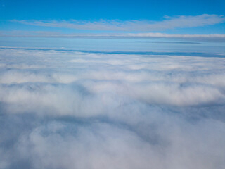 Aerial view. Flying over white clouds during the day in sunny weather.
