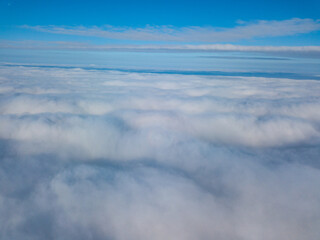 Aerial view. Flying over white clouds during the day in sunny weather.
