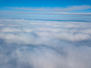 Aerial view. Flying over white clouds during the day in sunny weather.
