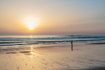 Chica solitaria en la playa al atardecer
