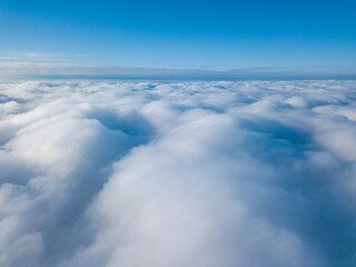 Aerial view. Flying over white clouds during the day in sunny weather.