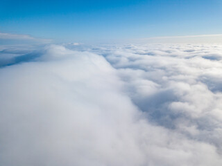 Aerial view. Flying over white clouds during the day in sunny weather.