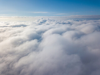 Aerial view. Flying over white clouds during the day in sunny weather.