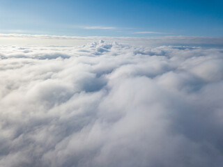 Aerial view. Flying over white clouds during the day in sunny weather.