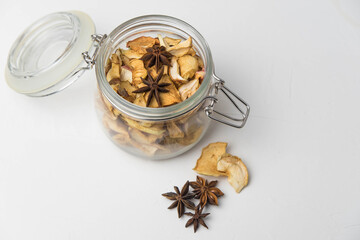 Homemade crispy sun dried organic apple slices. Close up of apple chips with spice in glass jar isolated on white background with copy space for text