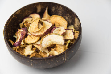 Homemade crispy sun dried organic apple slices. Close up of apple chips with spice in bowl isolated on white background with copy space for text