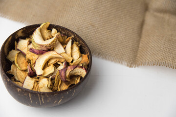 Homemade crispy sun dried organic apple slices. Close up of apple chips with spice in bowl isolated on white background with copy space for text