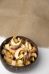 Homemade crispy sun dried organic apple slices. Close up of apple chips with spice in bowl isolated on white background with copy space for text