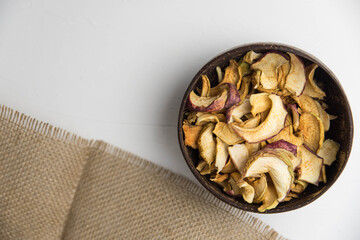 Homemade crispy sun dried organic apple slices. Close up of apple chips with spice in bowl isolated on white background with copy space for text