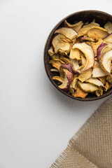 Homemade crispy sun dried organic apple slices. Close up of apple chips with spice in bowl isolated on white background with copy space for text
