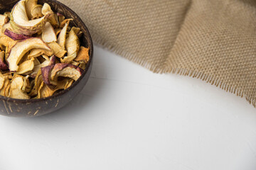 Homemade crispy sun dried organic apple slices. Close up of apple chips with spice in bowl isolated on white background with copy space for text