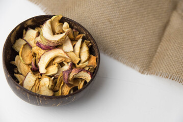 Homemade crispy sun dried organic apple slices. Close up of apple chips with spice in bowl isolated on white background with copy space for text