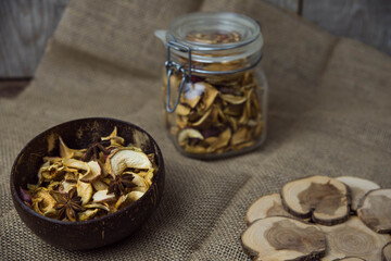 Homemade crispy sun dried organic apple slices. Close up of apple chips with spice in bowl on brown wooden background with copy space for text
