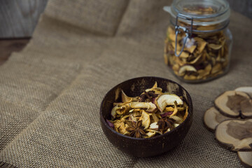 Homemade crispy sun dried organic apple slices. Close up of apple chips with spice in bowl on brown wooden background with copy space for text