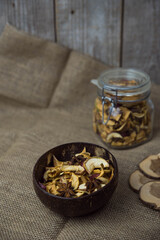 Homemade crispy sun dried organic apple slices. Close up of apple chips with spice in bowl on brown wooden background with copy space for text