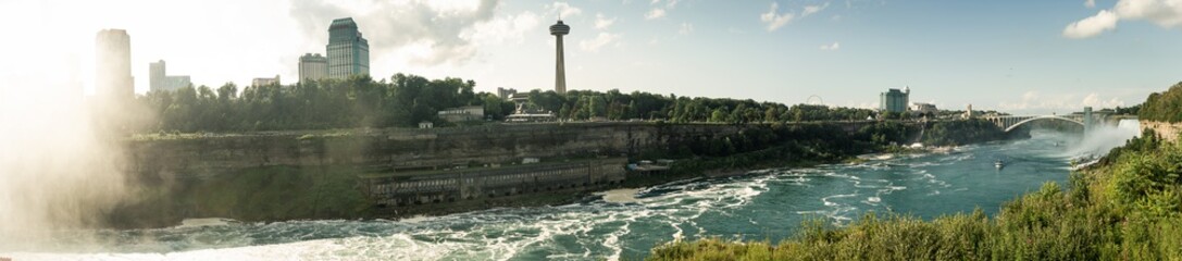 Panorama view of Rainbow Bridge over Niagara river and sightseeing boat below together with...