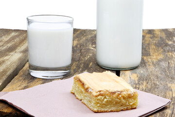 A glass and bottle of milk on a white wooden background. Breakfast in a morning. Cake. Healthy food