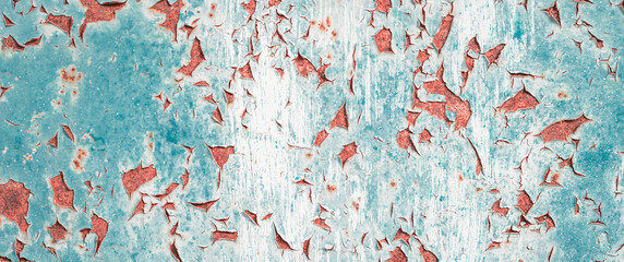 Old grungy cracked distressed white and orange and teal weathered wall paint peeling off rusted...