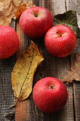 Juicy red apples and autumn leaves on the table