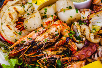 Seafood platter.Grilled lobster, shrimps, scallops, langoustines, octopus, squid on white plate.
