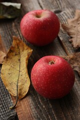 Juicy red apples and autumn leaves on the table