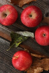 Juicy red apples and autumn leaves on the table