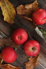 Juicy red apples and autumn leaves on the table