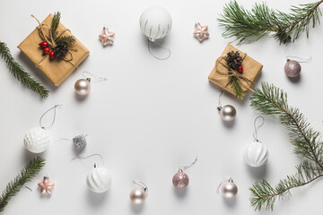 Christmas composition. Frame made of christmas gifts, pine branches, toys on white background. Flat lay, top view, copy space.
