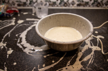 Messy kitchen with splattered batter on worktop after teen attempted to prepare Brownies